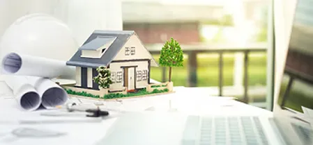 Model house with keys and blueprints representing real estate app development