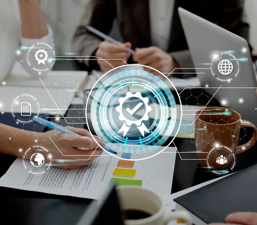 Team reviewing printed reports and a laptop beneath a glowing certified-shield hologram