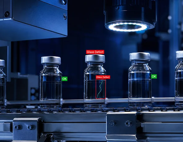 Machine vision camera inspecting glass vials on a production line and flagging glass defects