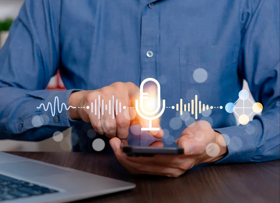 A person holding a phone with a glowing microphone icon and sound waves above it